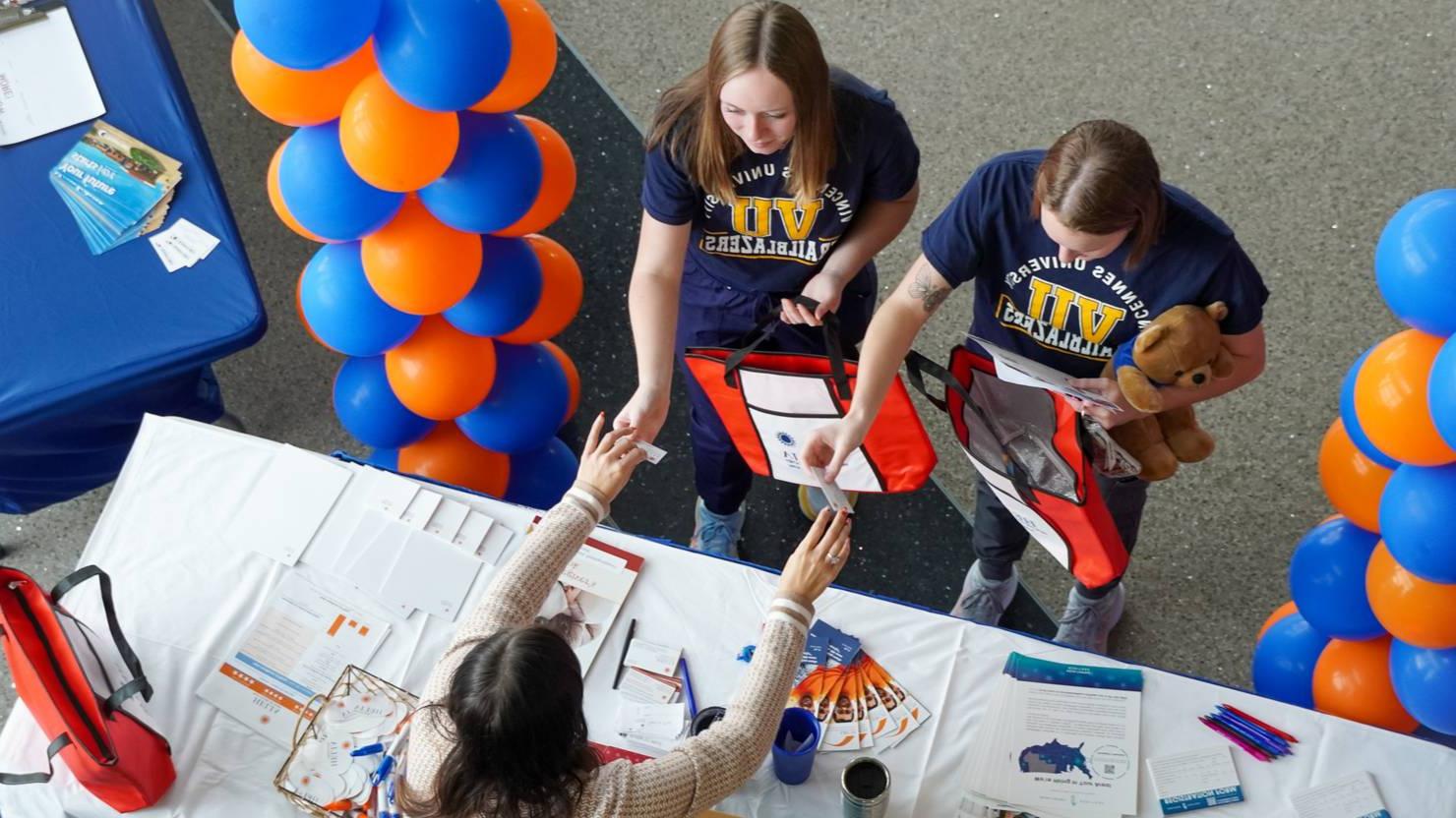 Students at the  career fair get information from a booth